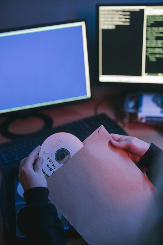 persona guardando un disco frente al ordenador protegiendo datos