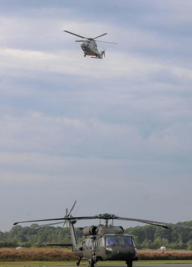 helicoptero volando sobre otro helicoptero militar